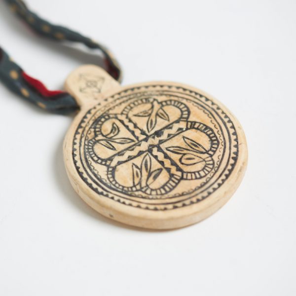 Round wooden carved pendant